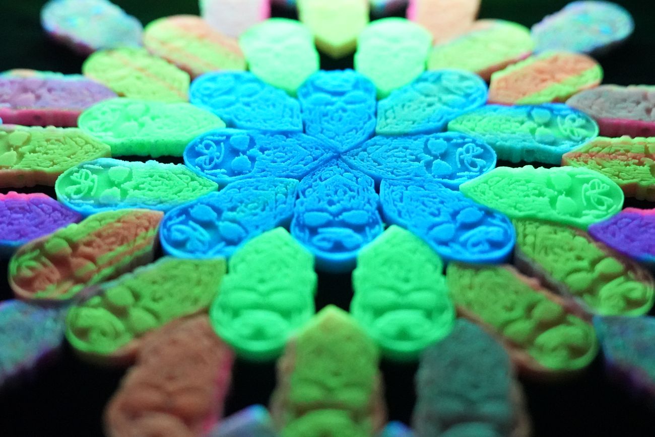 Glow-in-the-dark resin prints arranged in a mandala