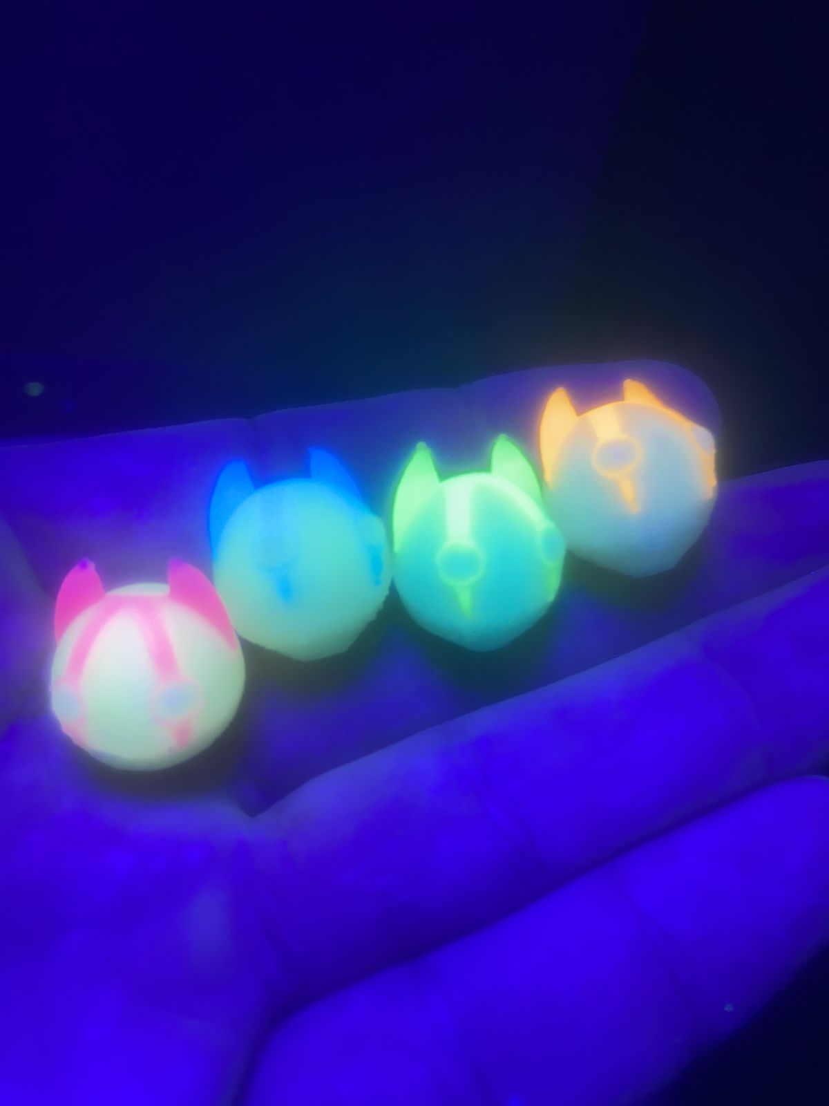 UV-reactive printed minis glowing under blacklight